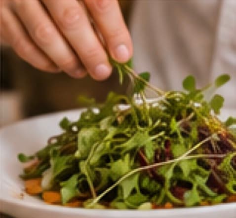 Microgreens being placed on a plate